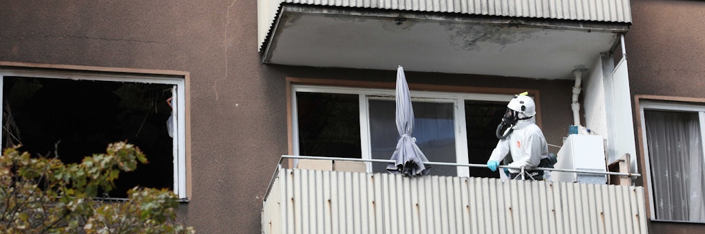 Ein Brandermittler steht am Freitagmorgen auf dem Balkon der ausgebrannten Wohnung.