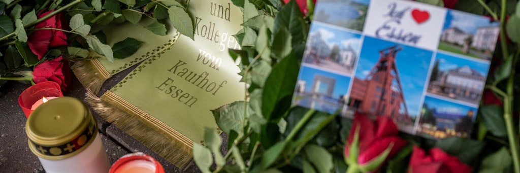 Ein Blumenkranz und Kerzen sind vor der verschlossenen Tür einer Galeria Kaufhof Filiale in Essen niedergelegt worden.
