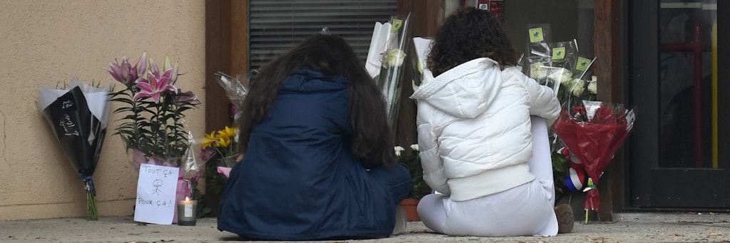 Schülerinnen trauern vor dem Schulgebäude um den ermordeten Lehrer.