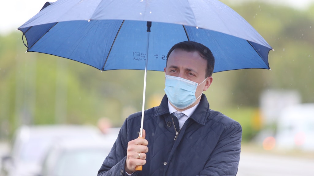 Paul Ziemiak, Generalsekretär der CDU, steht mit Mund- und Nasenschutz und Regenschirm bei einer Veranstaltung