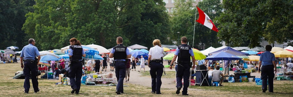 olizisten gehen über den bisherigen, provisorisch errichteten „Thaipark“.