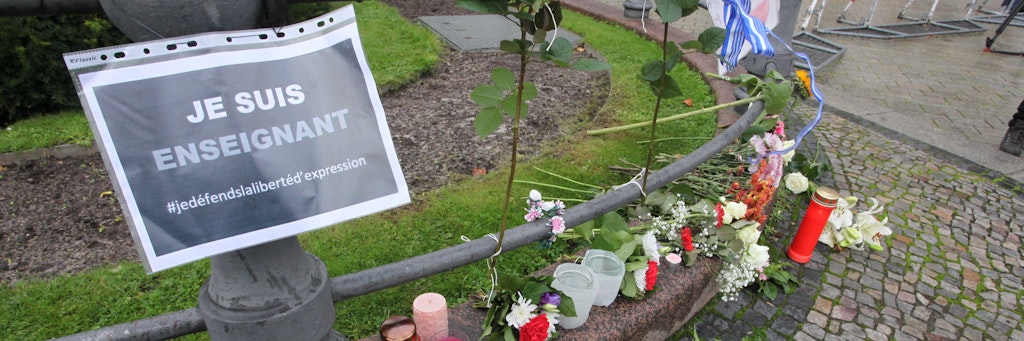 Teilnehmer der Mahnwache legten Blumen nieder. Auf dem Schild steht: „Je suis enseignant“ (dt.: Ich bin Lehrer).