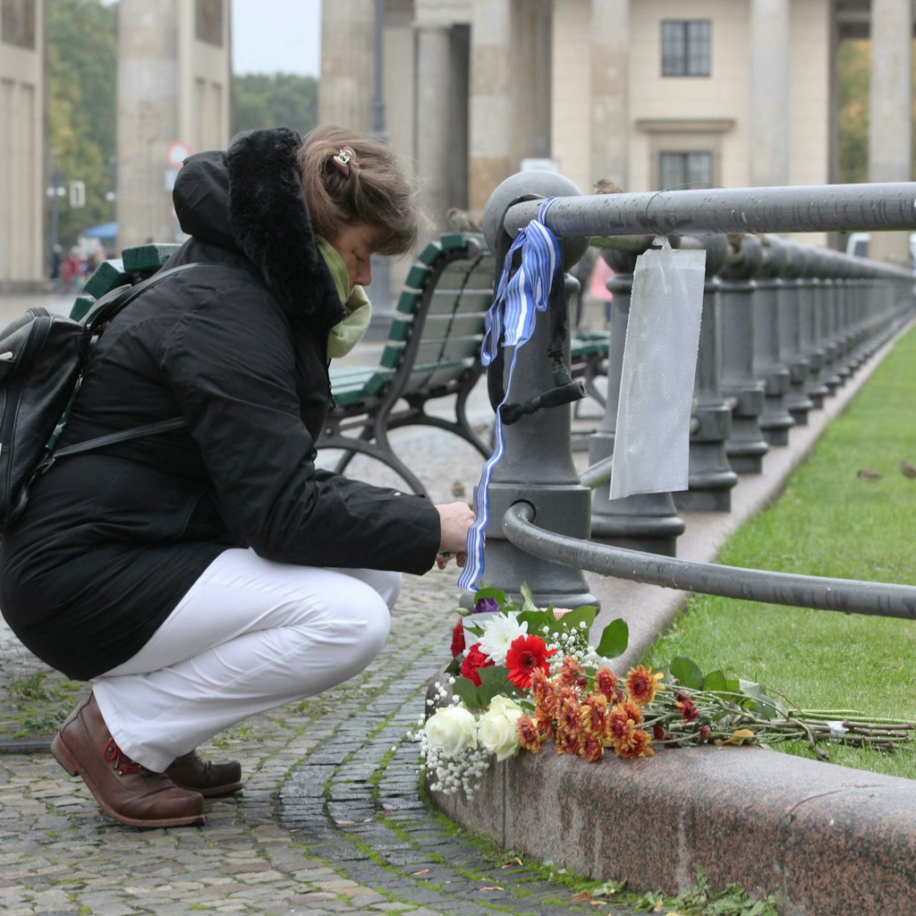 Eine Frau kniet nieder und hält inne.
