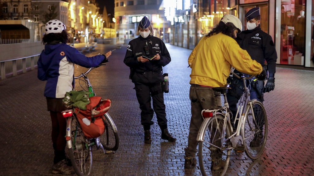 Polizisten kontrollieren in Brüssel Radlerinnen: Seit der Nacht zu Dienstag darf in Belgien niemand mehr zwischen Mitternacht und 5 Uhr früh das Haus verlassen. 
