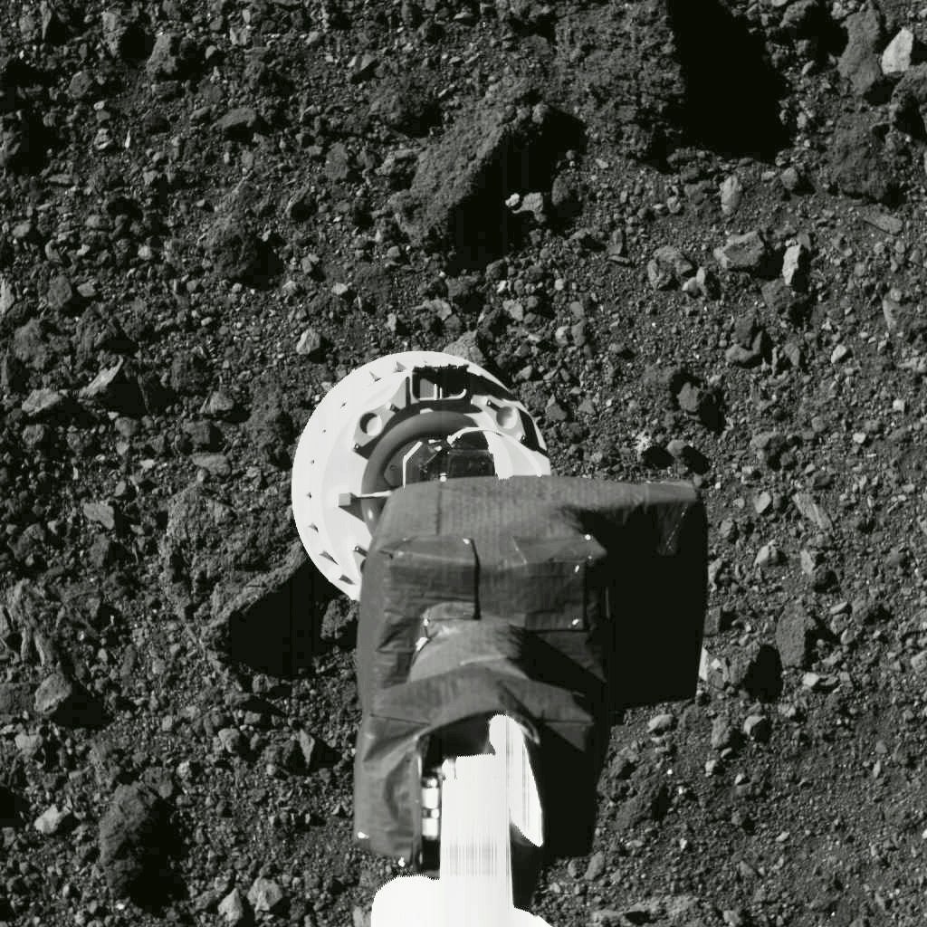 Ein Arm von „Osiris Rex“ greift nach Staub und Geröll auf dem Asteroiden Bennu.