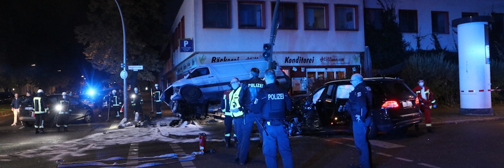 Einsatzkräfte der Polizei stehen in der Nacht zu Donnerstag in Steglitz, im Hintergrund ist der nicht mehr fahrbereite Transporter des Amokfahrers zu sehen.