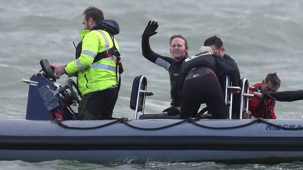 John Bream winkt aus dem Boot, das ihn nach seinem Sprung aus etwa 40 Metern Höhe ins Meer geborgen hat. 