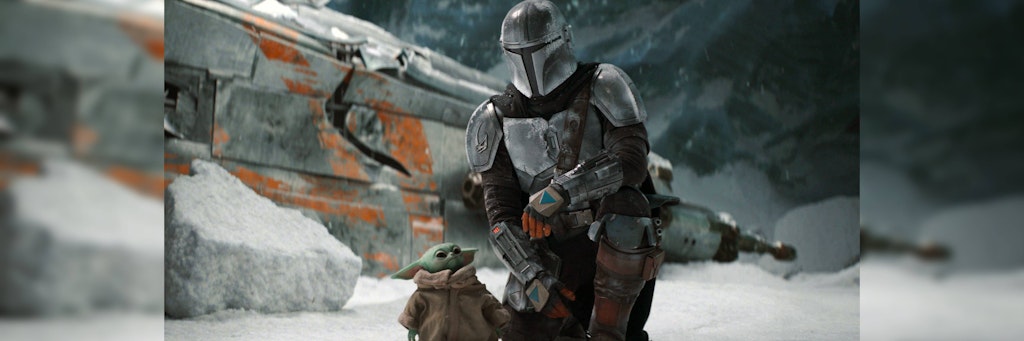 Der Mandalorianer Din Djarin mit „Baby Yoda“ auf einem Eisplaneten.