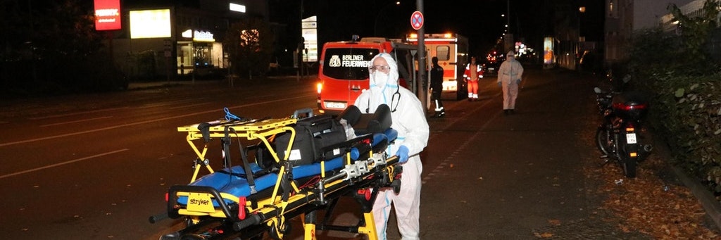 Ein Sanitäter mit einer Spezialtrage für die erkrankten Bewohner