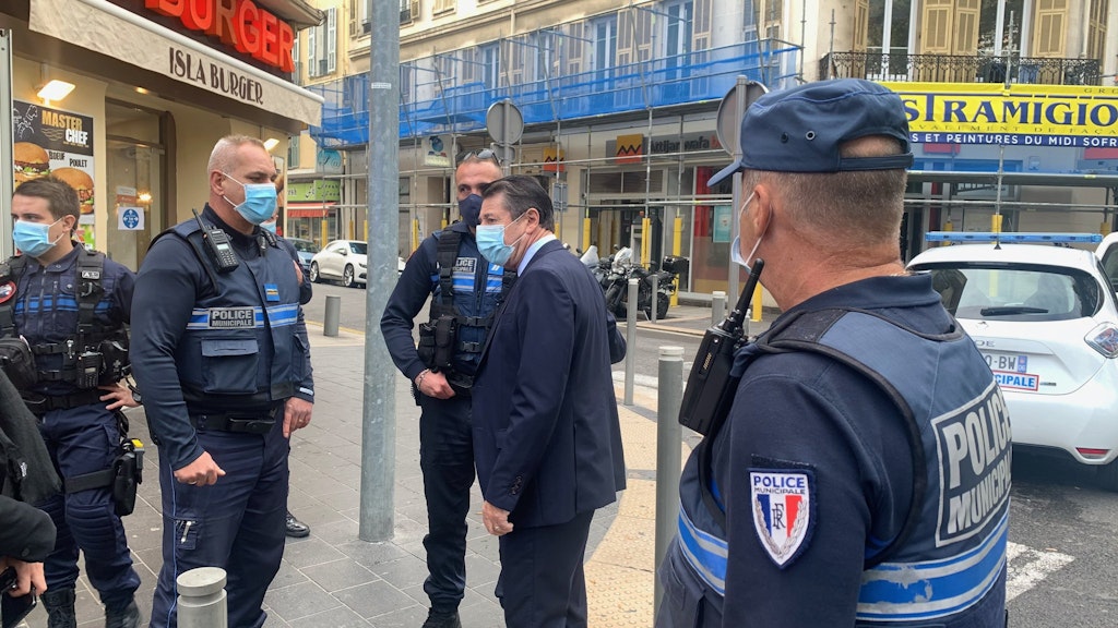 Christian Estrosi (2.v.r), Bürgermeister von Nizza, spricht mit Polizeibeamten am Ort eines Messerangriffs. 