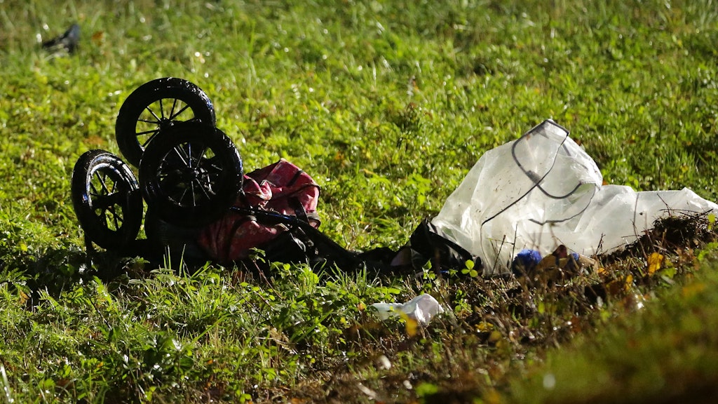 Ein zerstörter Kinderwagen liegt nach dem Unfall auf der Wiese. 