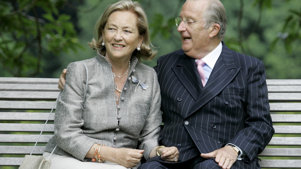 Belgiens Königin Paola und König Albert II. sitzen im Königlichen Palast auf einer Bank.