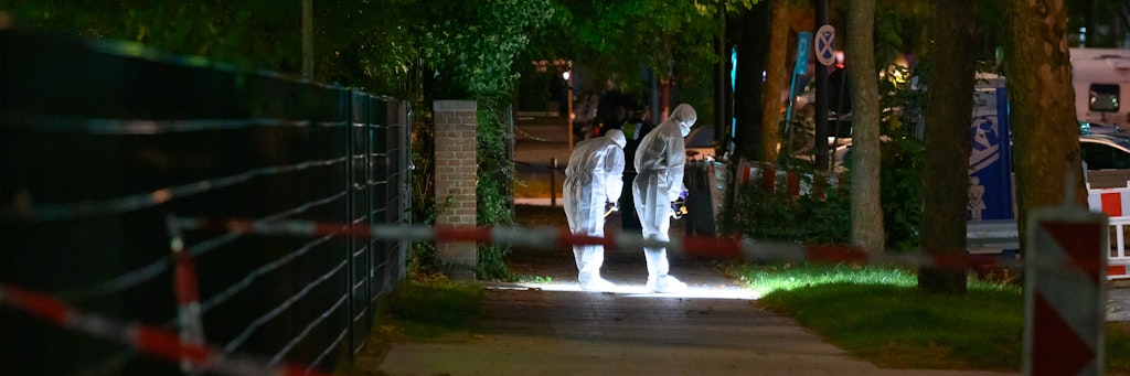 Polizisten suchen am Tatort nach Spuren.