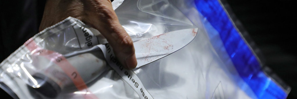 Ein Kriminaltechniker stellt ein Messer am Tatort sicher.