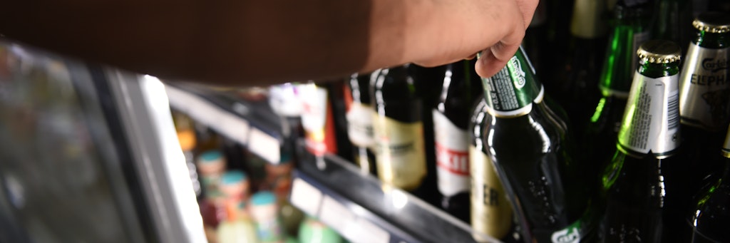 Ein Mann holt eine Flasche Bier aus einem Kühlschrank in einem Spätkauf in Berlin-Mitte.