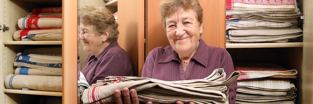 Gisela Meyer vor ihrem Wäscheschrank – er ist prall gefüllt mit den Tüchern.