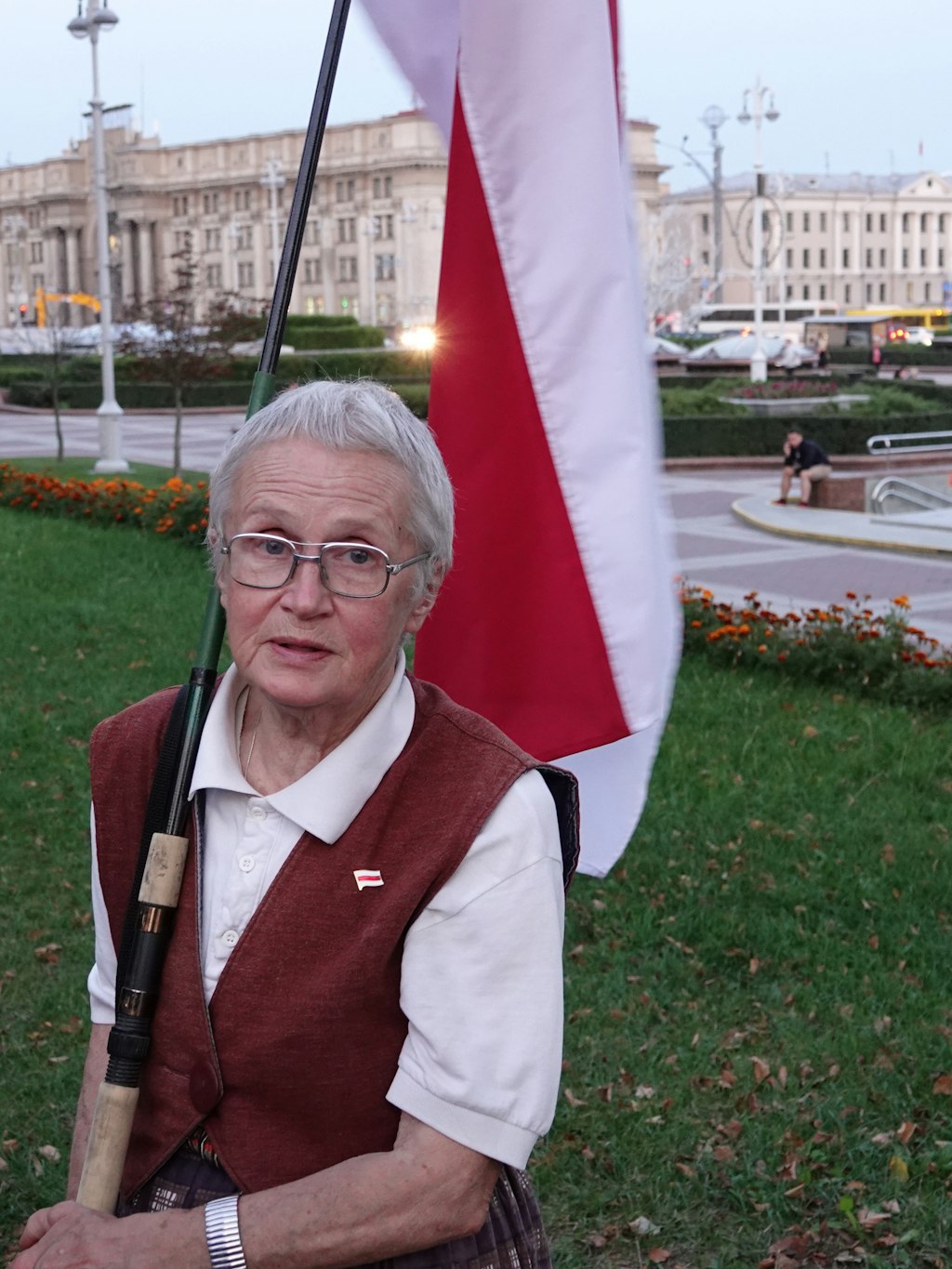 Nina Baginskaja steht auf dem Unabhängigkeitsplatz an der katholischen Roten Kirche mit ihrer selbst genähten weiß-rot-weißen Fahne. 