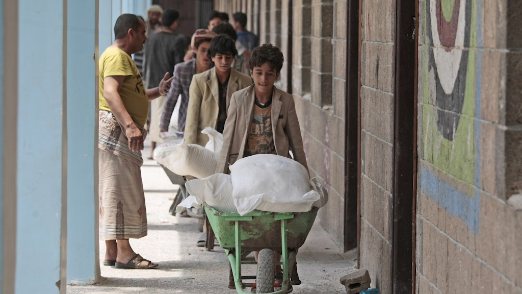 Vertriebene im Jemen holen in einer Schule mit Schubkarren Lebensmittel, die das WFP geliefert hat. 