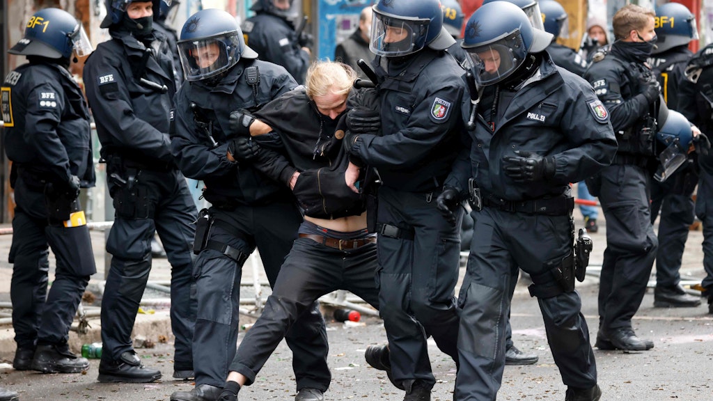 Polizisten führen einen Randalierer ab.