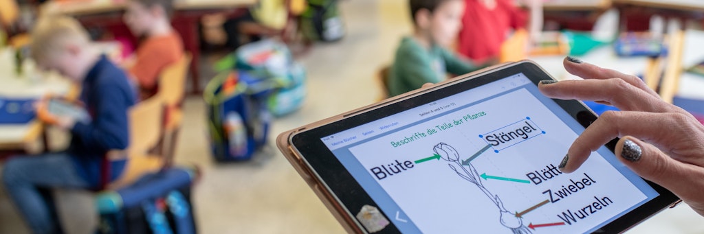 Eine Lehrerin bedient in einer Grundschule ein Tablet. 