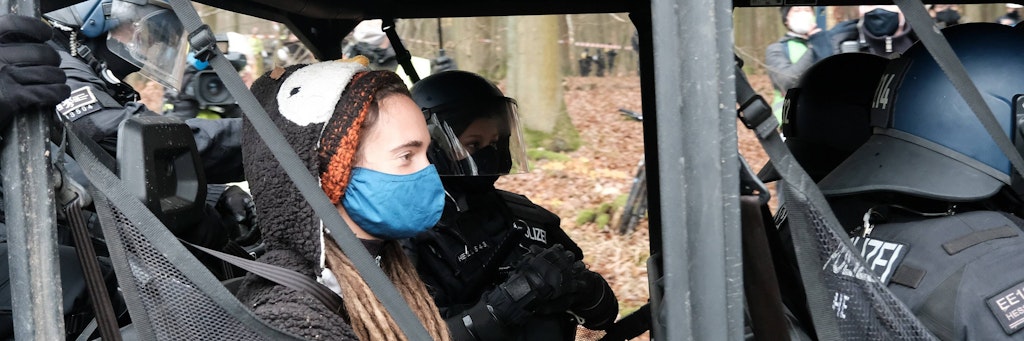 Polizisten bringen Carola Rackete aus dem Wald.