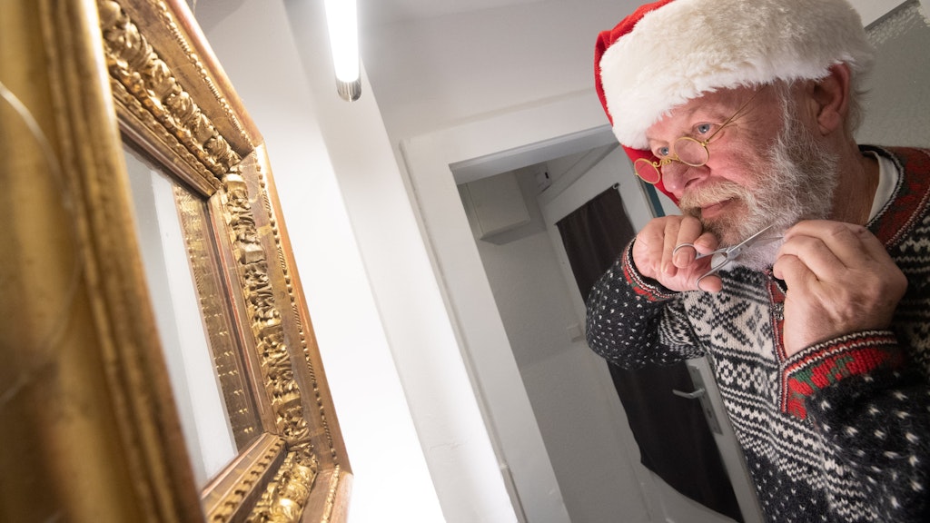 Willi Dahmen, professioneller Weihnachtsmann-Darsteller, kürzt mit einer Schere seinen Bart. 