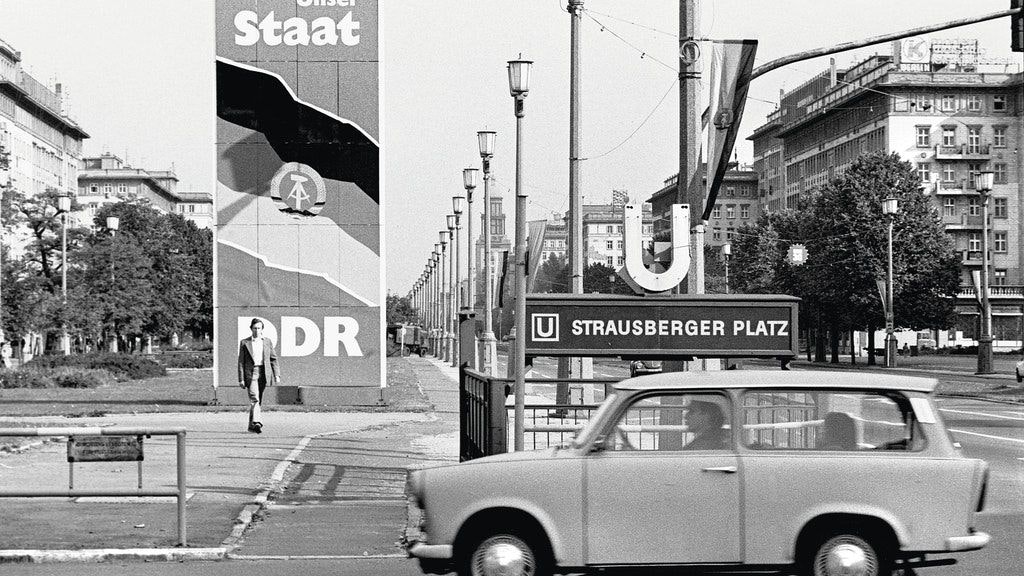 Losungen und Flaggen am Strausberger Platz in Friedrichshain weisen 1979 auf den 30. Jahrestag der DDR hin.