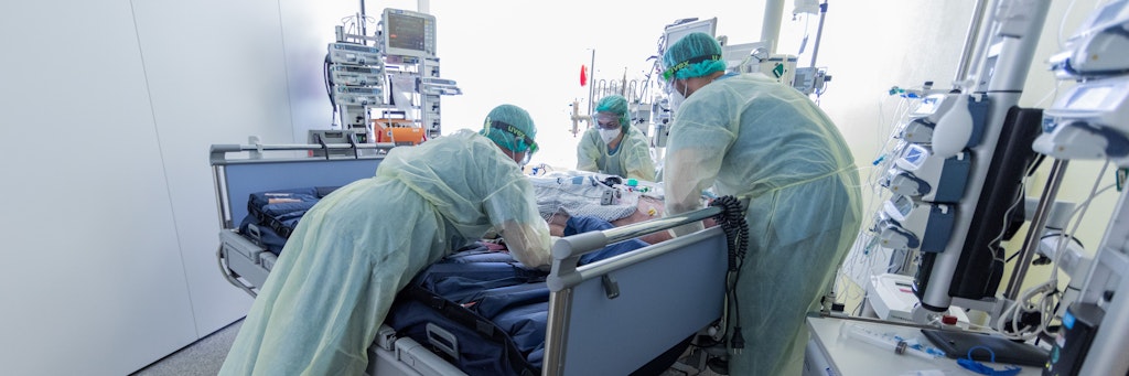 Intensivpflegekräfte transportieren einen beatmeten Corona-Patienten auf die Intensivstation. 
