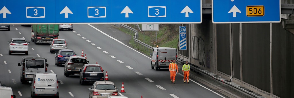 Mitarbeiter eines Verkehrssicherungsdienstes untersuchen die Stelle, an der am Freitag eine Betonplatte auf das Auto einer 66-jährigen Kölnerin gestürzt war. 