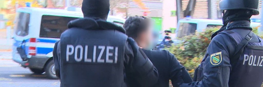 Einer der Verdächtigen wird in Neukölln von der Polizei abgeführt.