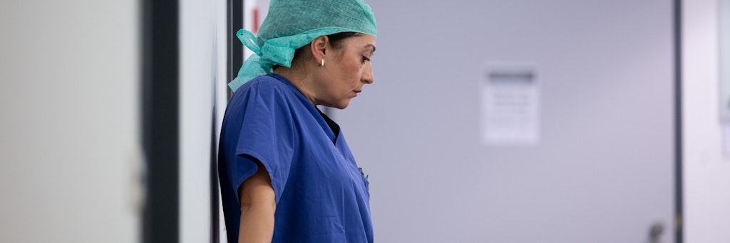Ayse Yeter, Krankenschwester und Stationsleitung der Intensivstation für Covid-19 Patienten des Klinikum Stuttgart, lehnt im Zugangsbereich zur Intensivstation an einem Geländer. 