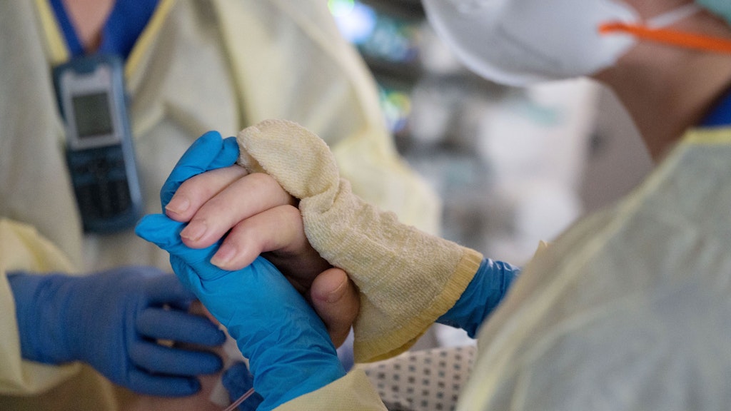 Ayse Yeter wäscht mit einer Kollegin einen Patienten, der im künstlichen Koma liegt und beatmet wird. 