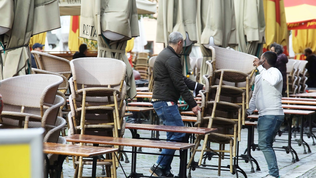 Am Hackeschen Markt werden die Stühle eines Restaurants zusammengepackt.