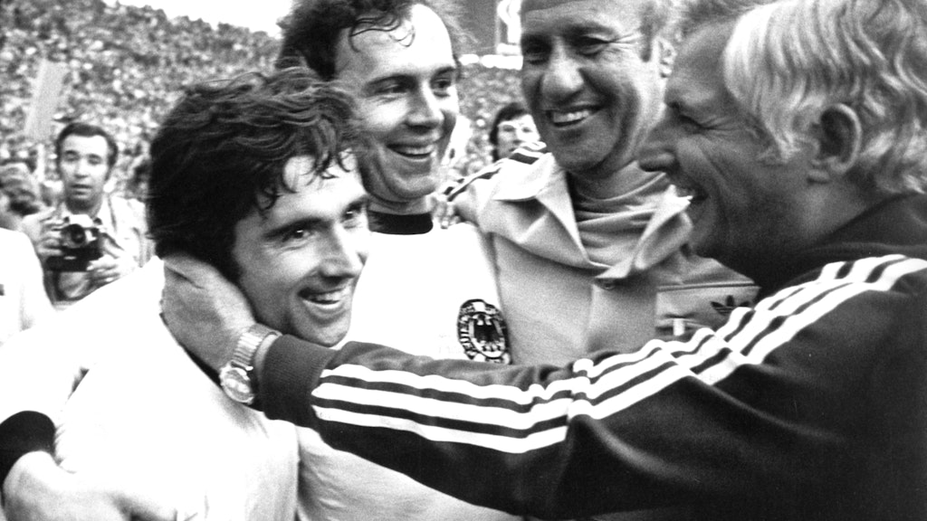 Müller, Bundestrainer Helmut Schön (2.v.r), sein Assistent Jupp Derwall (r), und Kapitän Franz Beckenbauer (2.v.l) bejubeln den WM-Triumph 1974. 