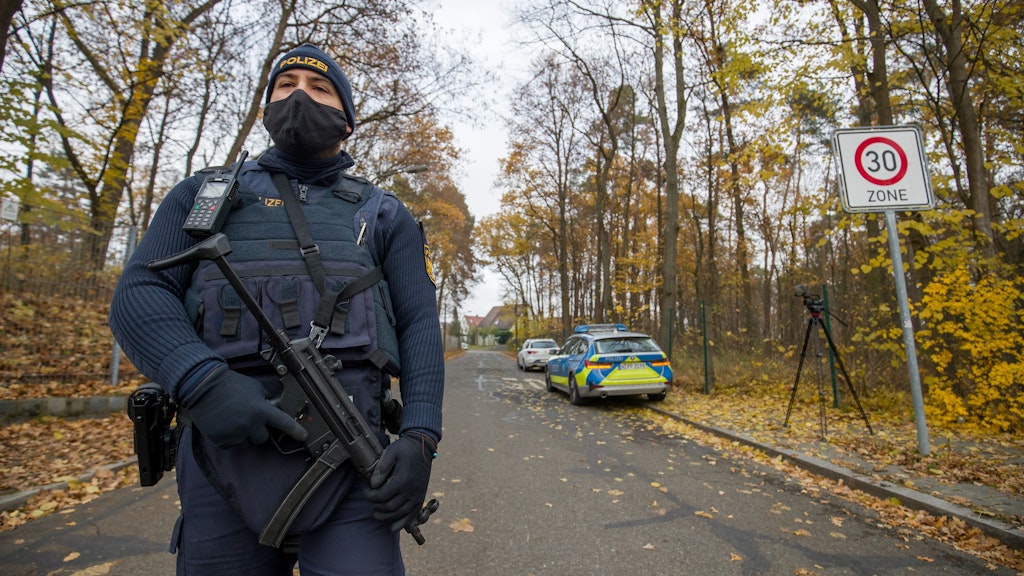 Ein Polizist bewacht die Zufahrt zu einem Wohnviertel in Nürnberg. In diesem wurden zuvor auf offener Straße zwei Menschen erschossen. 