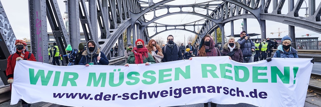 Teilnehmende des Schweigemarschs auf der Bornholmer Brücke in Berlin.