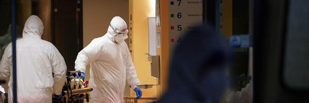 Sanitäter schieben in einem Seniorendomizil im Stadtteil Lichtenberg eine Tragbahre. 