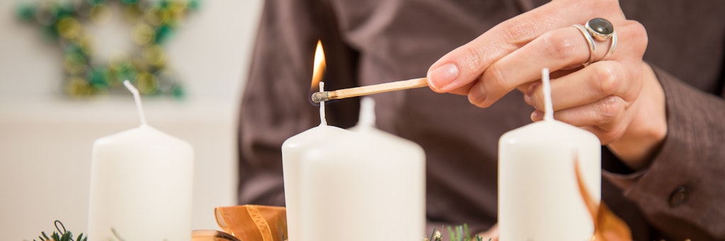 Brennende Kerzen auf dem Adventskranz sollten nicht unbeaufsichtigt bleiben. Sonst kann es nach einem Brand Probleme mit dem Versicherungsschutz geben.
