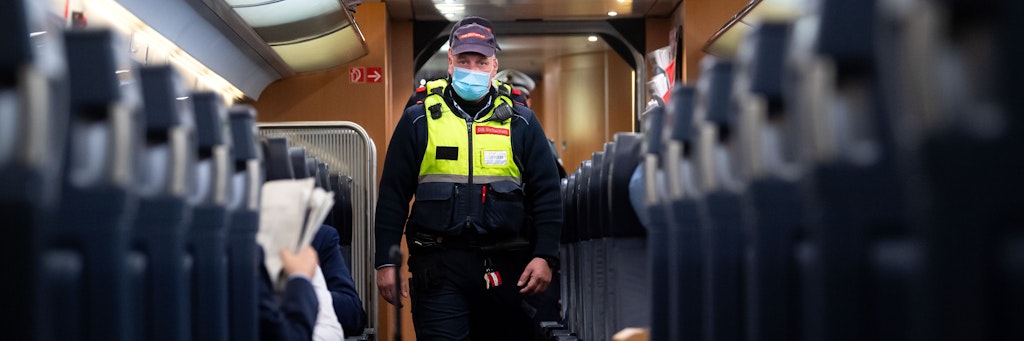 Sicherheitsmitarbeiter der Deutsche Bahn kontrollieren die Einhaltung der Maskenpflicht in einem ICE.