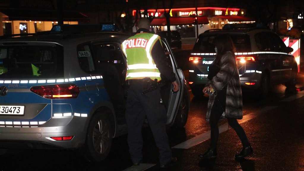 Die betrunkene Unfallfahrerin auf dem Weg zu einem Polizeiauto.