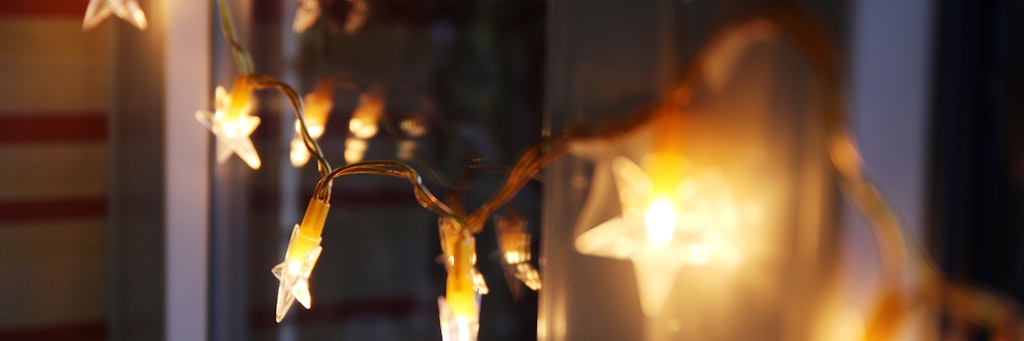 Eine LED-Lichterkette hängt an einem Fenster. 