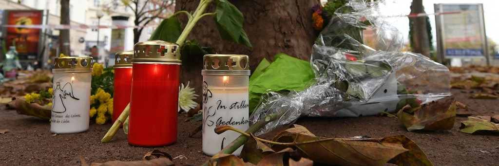 Kerzen und Blumen stehen nach der Terror-Nacht von Wien an einem Baum.