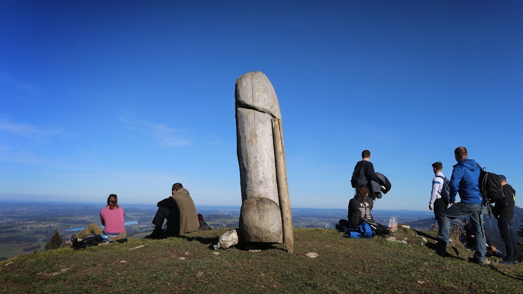 Wanderer genießen neben der zwei Meter hohen Penis-Skulptur aus Holz auf dem Grat des Grünten den Ausblick. Jetzt ist der Holz-Phallus weg.