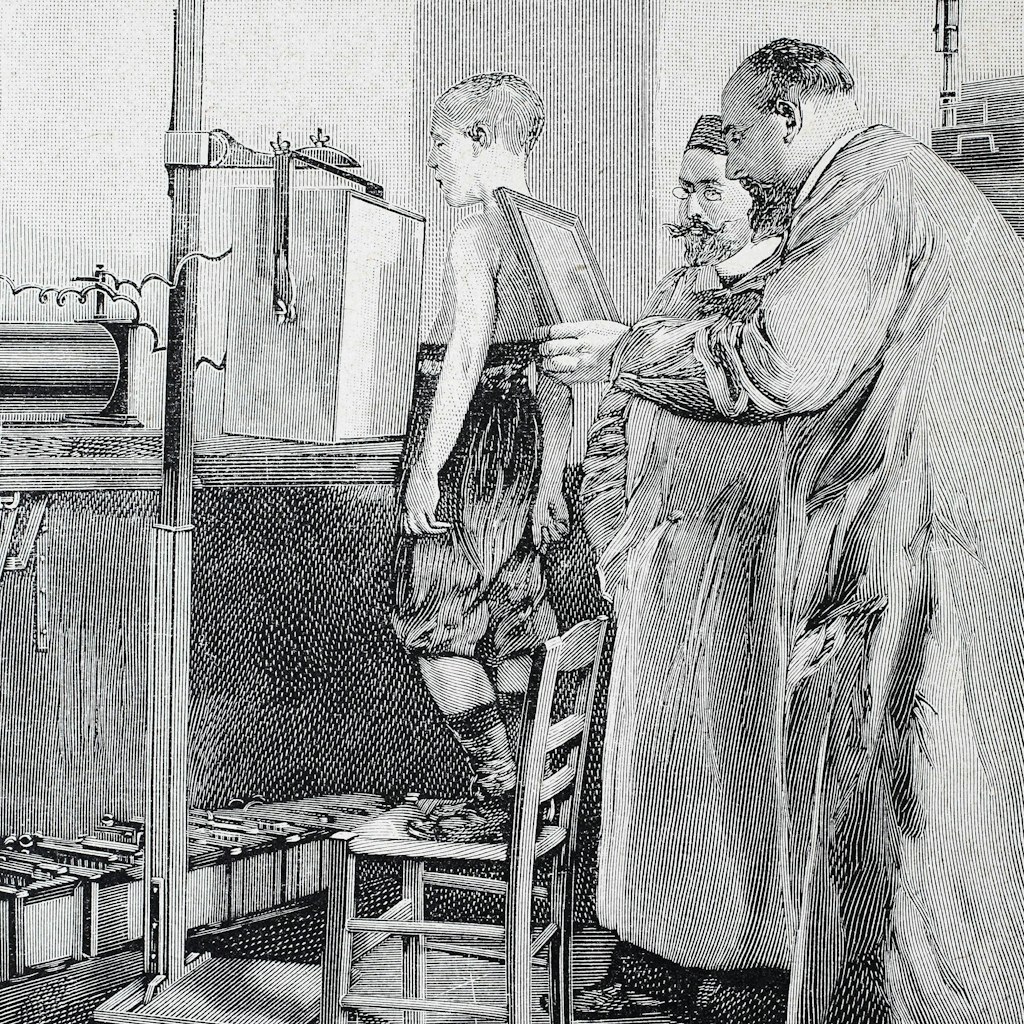 Diese historische Darstellung von 1890 zeigt einen jungen Patienten, wie er mit Röntgenstrahlen untersucht wird. 