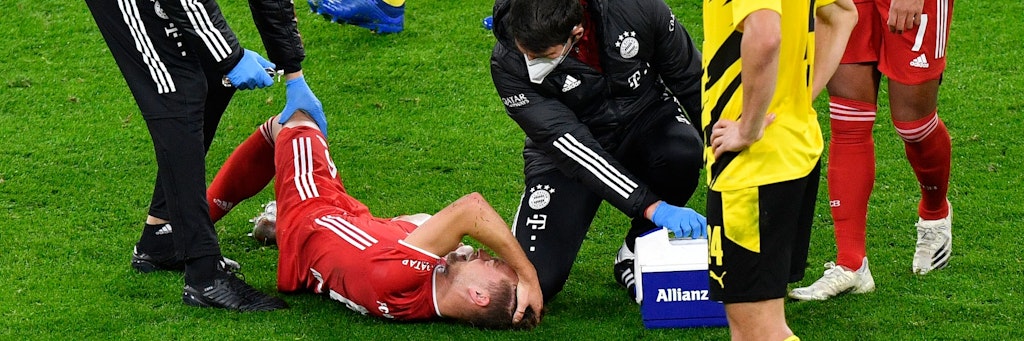 Joshua Kimmich wird auf dem Platz untersucht, rauft sich vor Schmerzen die Haare. 