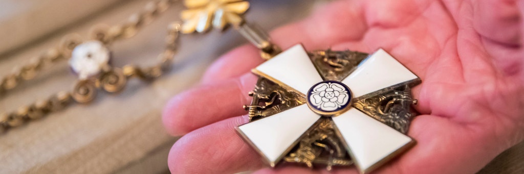 Auktionator Andreas Thies zeigt die Ordenskette der weißen Rose von Finnland für Staatsoberhäupter aus dem Besitz Erich Honeckers. Für dieses Objekt wurde bei der Versteigerung der höchste Preis erzielt. 