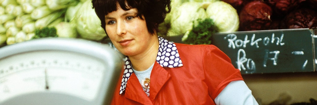 Rotkohl, Weißkohl, Chinakohl: eine Gemüseverkaufstelle im Jahr 1980. Immerhin leuchtet die Dederon-Kittelschürze in frischem Tomatenrot.