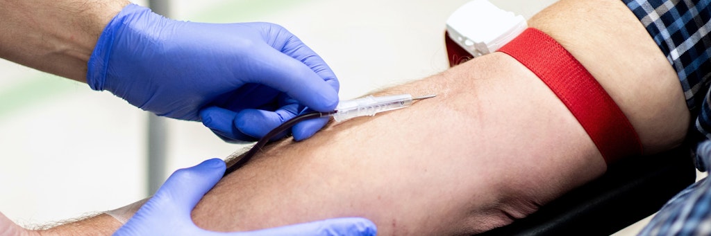 Einem Mann wird Blut abgenommen. (Symbolbild)