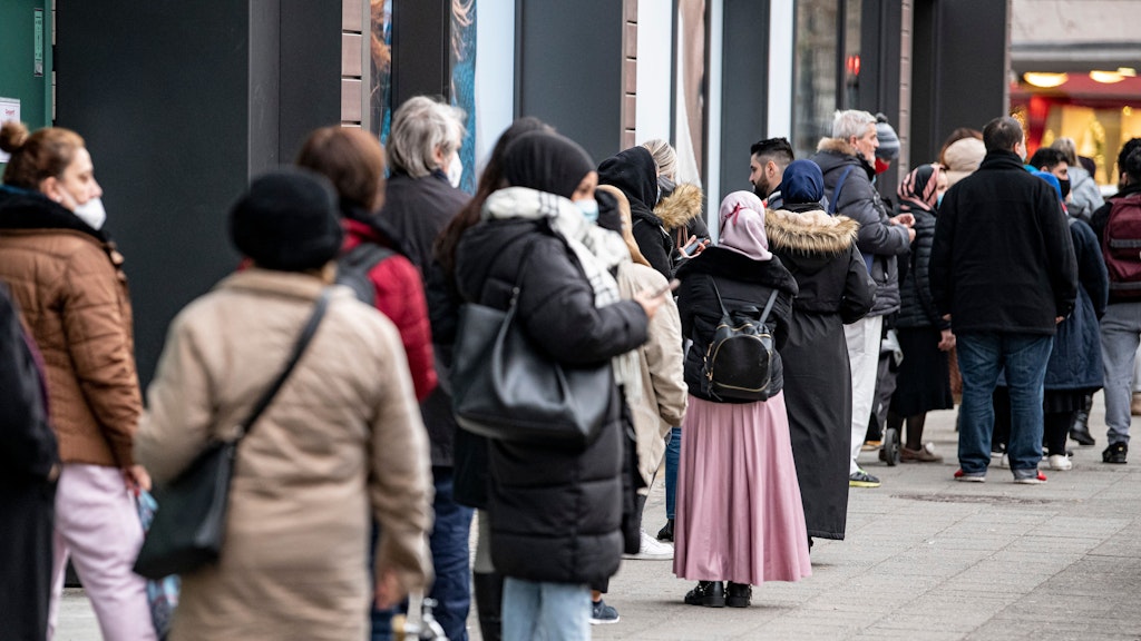 Letzte Gelegenheit zum großen Weihnachts- Shoppen. Einen Tag vor dem Lockdown warten Menschen in einer langen Schlange vor einem Bekleidungsgeschäft auf dem Kurfürstendamm.