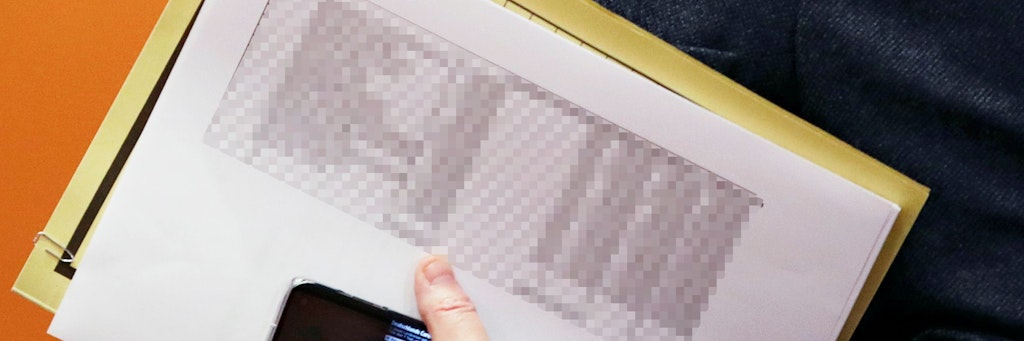 In den Händen trägt Kanzlerin Angela Merkel eine vertrauliche Impfliste, die auf diesem Bild gepixelt wurde.